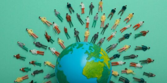 a globe surrounded by model people of all races on a green background representing privacy law compliance